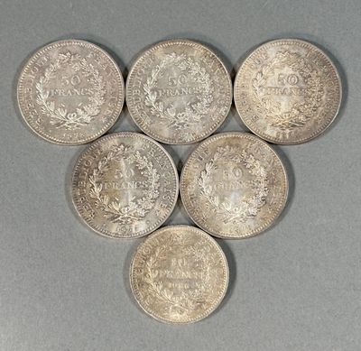 six pièces d'argent de tailles et de formes différentes posées sur une surface grise
