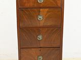 une petite commode en bois posée sur un sol carrelé