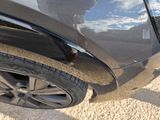 a close up of a car ' s tire with a person standing in the background
