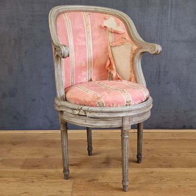 une chaise sur laquelle est posé un coussin rayé rose et blanc