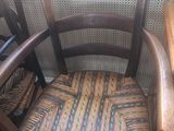 une chaise en bois avec une assise tressée et un panier sur le dossier