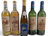 six bouteilles de vin sont alignées sur une surface blanche