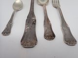 five silver spoons and two silver spoons on a white table