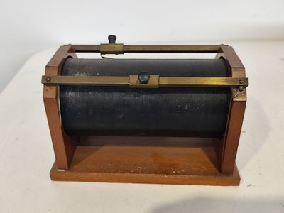 une vieille boîte en bois munie d'une poignée métallique, posée sur une surface blanche