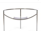 a close up of a curved glass table with a metal frame