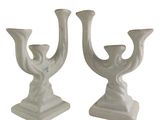 pair of white ceramic candlesticks with a bird design on each of them