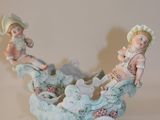 une figurine représentant deux enfants dans une calèche