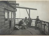 photo en noir et blanc d'un groupe d'hommes assis sur une terrasse