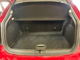 a red car with its trunk open in a garage