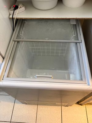 un petit réfrigérateur avec une porte vitrée dans une cuisine