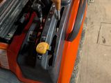 un chariot élévateur orange avec une caisse à outils à l'arrière