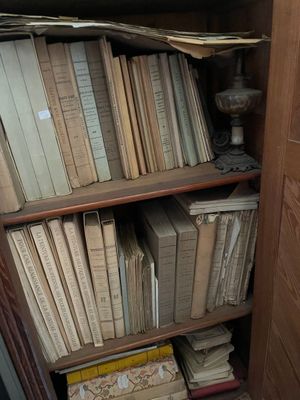 a book shelf with many books on it in the corner of a room