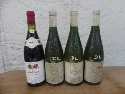 quatre bouteilles de vin sont alignées sur une table