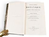 an open book with a gold glove on top of it