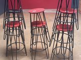 four stools with red seats sit in front of a red wall