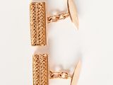 two pairs of gold cufflinks on a white surface