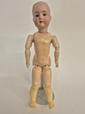 a small wooden doll that is standing on a rock