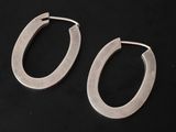 a pair of silver hoop earrings on a black background