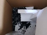 a box that has a toilet in it and a trash can
