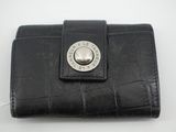 portefeuille en cuir noir orné d'un bouton métallique sur le devant