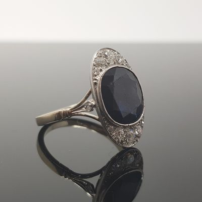 an image of a diamond and sapphire ring on a black surface
