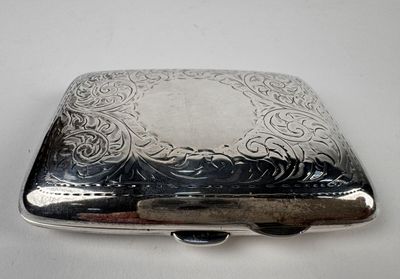 une boîte argentée ornée d'un motif sur une surface blanche