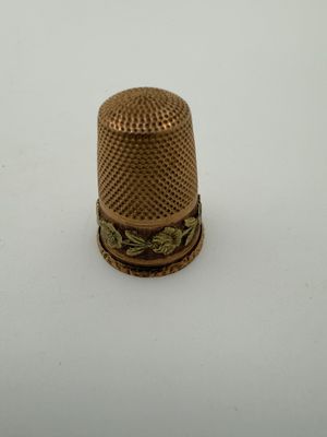 an antique thimble on a white surface with a white background