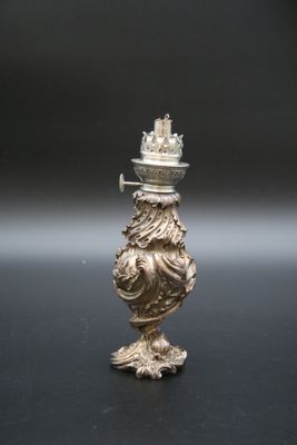 un bougeoir ancien en argent surmonté d'une couronne