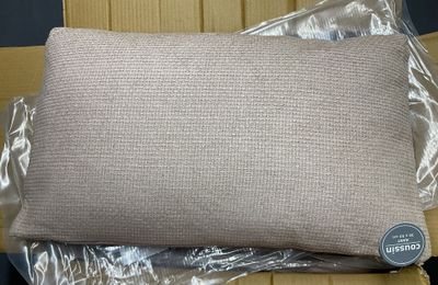 un gros plan d'un oreiller posé sur une boîte en carton