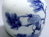 a blue and white vase with a bird on it