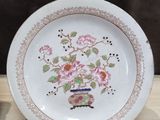 a white plate with pink flowers on it on a table