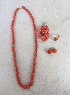necklace, earrings, and bracelet with coral beads on a white surface