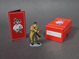 a figurine of a man in a trench coat next to a red box