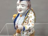 une figurine représentant un homme assis sur un rocher
