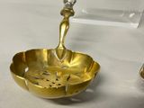 a gold bowl with a spoon in it on a table