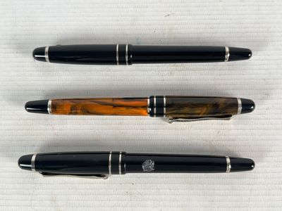 CHEVIGNON - Trois stylos à plume en résine noire ou marbrée,…