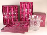 three wine glasses and a glass vase in a pink box