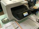 a printer sitting on top of a desk next to a phone