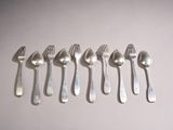 six forks and spoons are arranged in a row on a white surface
