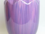 purple and white vase sitting on a white surface with a white background
