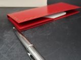 a pen that is sitting on a table next to a book