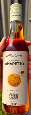 quelqu'un tient une bouteille d'amaretto à la main