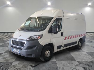 la camionnette blanche est garée sur un sol en damier dans le garage