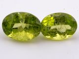 deux péridotites vertes de forme ovale sur une surface blanche
