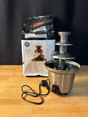 the chocolate fountain is sitting on a wooden table next to a bag of chocolate