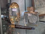 a glass table with a bottle of perfume and a cigar on it