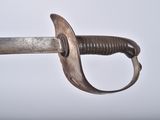 a close up of a sword on a white surface