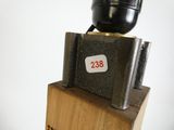 un petit objet noir posé sur un bloc de bois