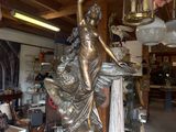 a statue of a woman holding a bird in a shop