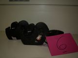 a pink sign on the counter next to a pair of black shoes